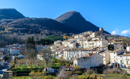 Houses in town against clear blue sky