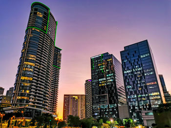 Low angle view of illuminated buildings against sky at sunset