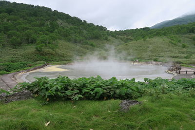 Scenic view of hot spring against sky