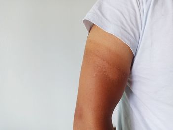 Midsection of woman standing against white background