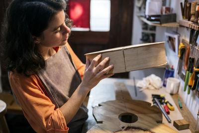 Midsection of woman holding while standing at table