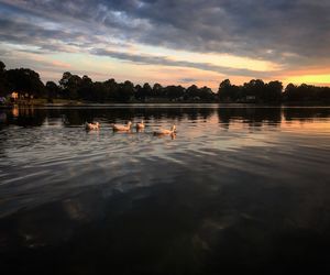 Scenic view of calm lake against cloudy sky during sunset