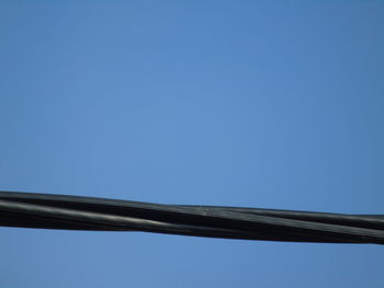 Low angle view of cables against clear blue sky