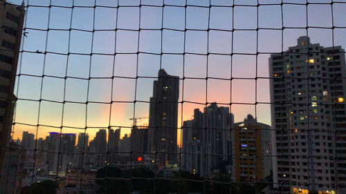 Buildings in city against sky during sunset