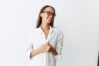 Portrait of female doctor standing against white background