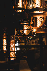 Close-up of illuminated light bulb hanging at night