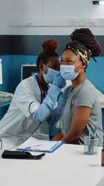Female doctor examining patient in office