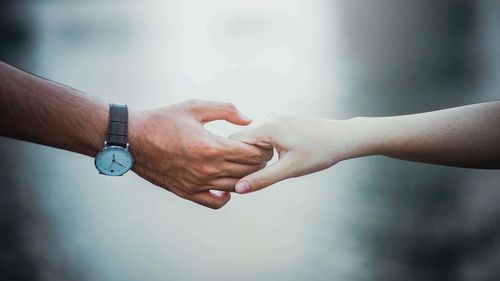 Cropped image of couple holding hands