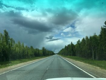 Road amidst trees against sky