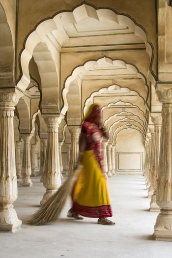 REAR VIEW OF WOMAN WALKING AT HISTORIC BUILDING