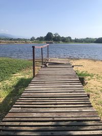 Wooden pier over lake against clear sky