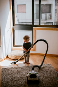 Full length of baby boy cleaning floor
