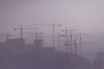 Construction site in city against sky at dusk