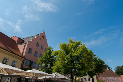 Low angle view of trees and buildings against sky