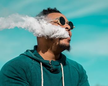 Close-up of man wearing sunglasses against sky