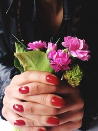 Close-up of woman holding pink flowers