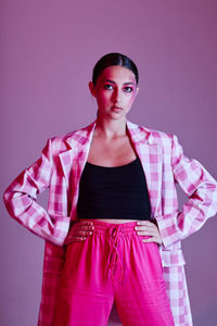 Young woman standing against gray background