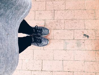 Low section of woman standing on tiled floor