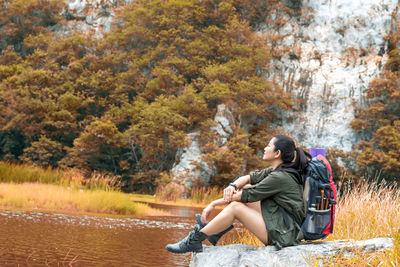 Young couple sitting on autumn tree