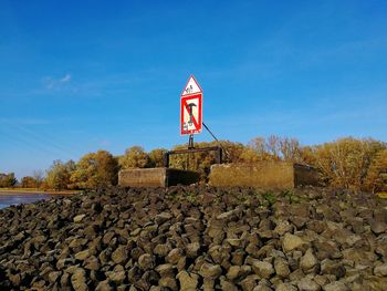 Lifeguard hut on rocks against clear blue sky