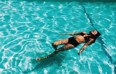 High angle view of young woman swimming in pool