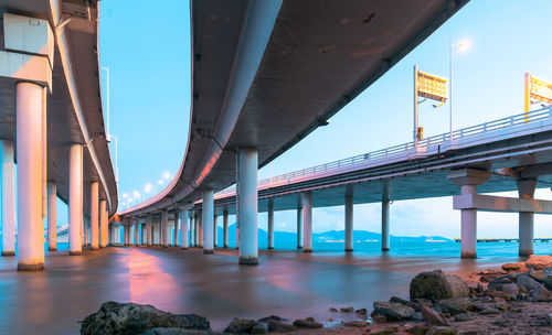 Bridge over road in city against sky