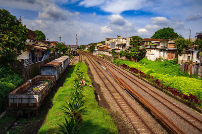 High angle view of railroad tracks by buildings against sky