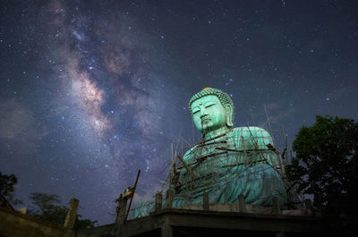 Giant buddha with milky way in sky at night, mae tha district, lampang province