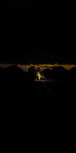 Silhouette landscape against sky at night