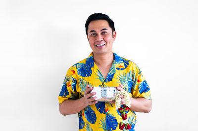 Portrait of young man standing against white background