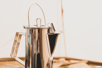 Close-up of glass container on table against white background