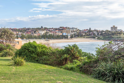 Scenic view of sea by buildings against sky