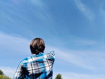 Rear view of woman looking at blue sky