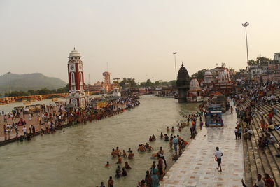 People at temple against sky during sunset