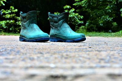 Close-up of shoes on street in park