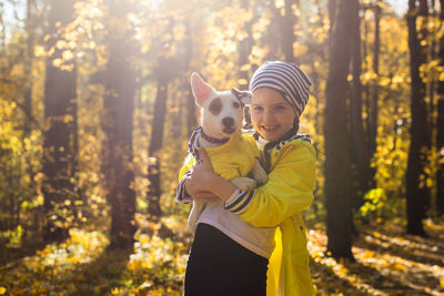 Rear view of woman with dog in forest