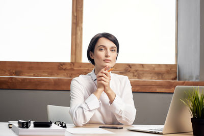 Woman using laptop while working at office