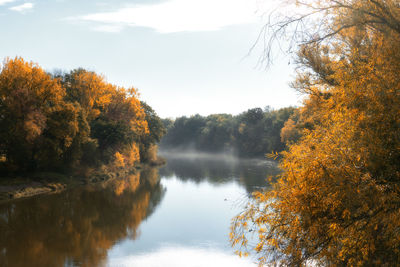 Scenic view of lake by trees against sky during autumn