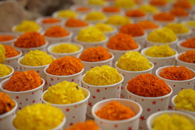 Close-up of marigold flowers in disposable cups