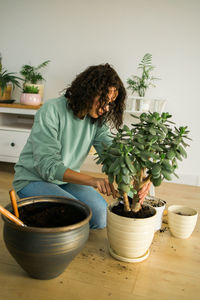 Young woman holding potted plant