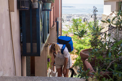 High angle view of woman with backpack standing on steps in city