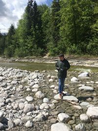 Full length of man standing on rock against trees