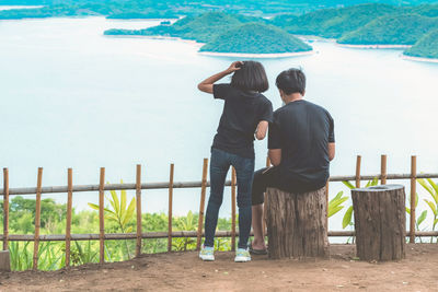 Rear view of couple standing by railing