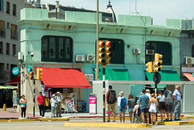 People on street against buildings in city