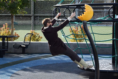 Full length of playful woman on merry-go-round at park