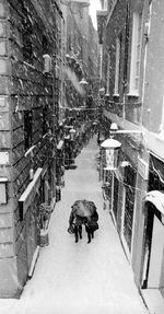 Panoramic view of people on street amidst buildings during winter