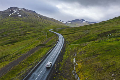 Lonely rent car drive on a remote road with beautiful scenery of iceland.