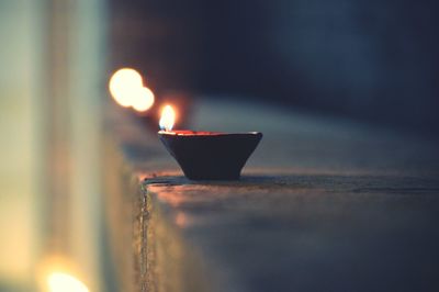 Close-up of illuminated diya on table