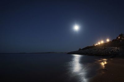 Scenic view of sea against clear sky at night