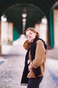 Woman looking away while standing in snow